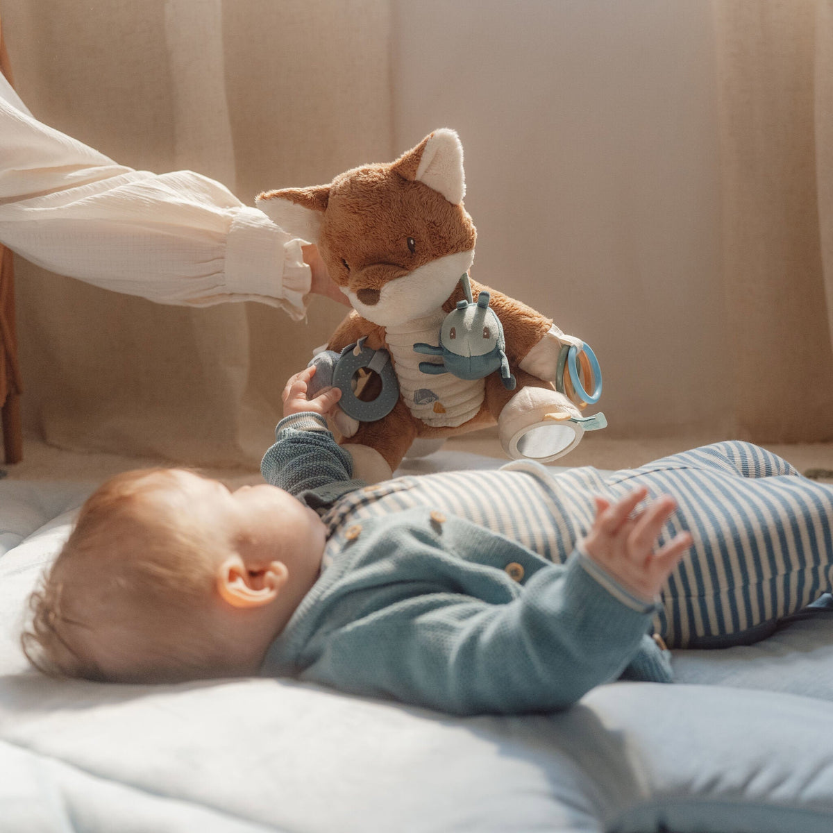Baby playing with the Little Dutch fox activity soft toy