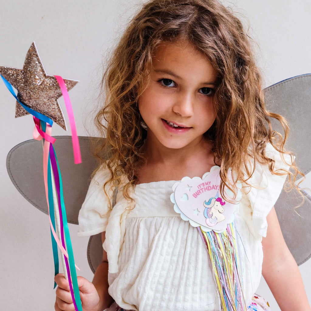 Child wearing Mimi & Lula unicorn birthday badge