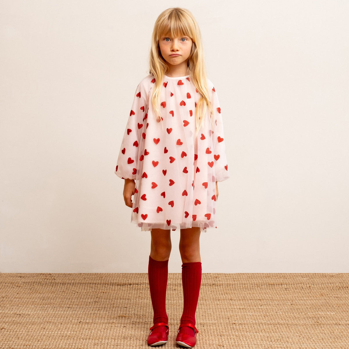 Child wearing pale pink red glitter heart balloon sleeve dress