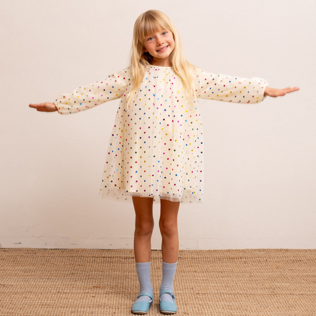 Child wearing vanilla spot balloon sleeve dress