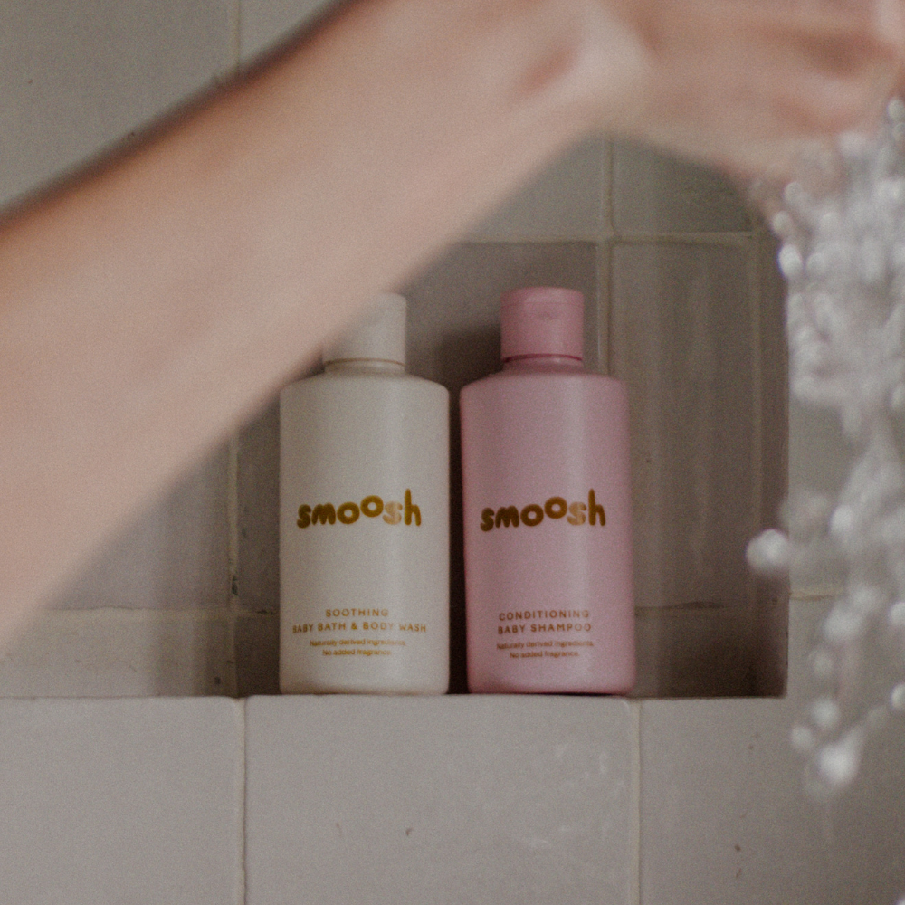 Smoosh baby shampoo and bath wash bottles beside the bath