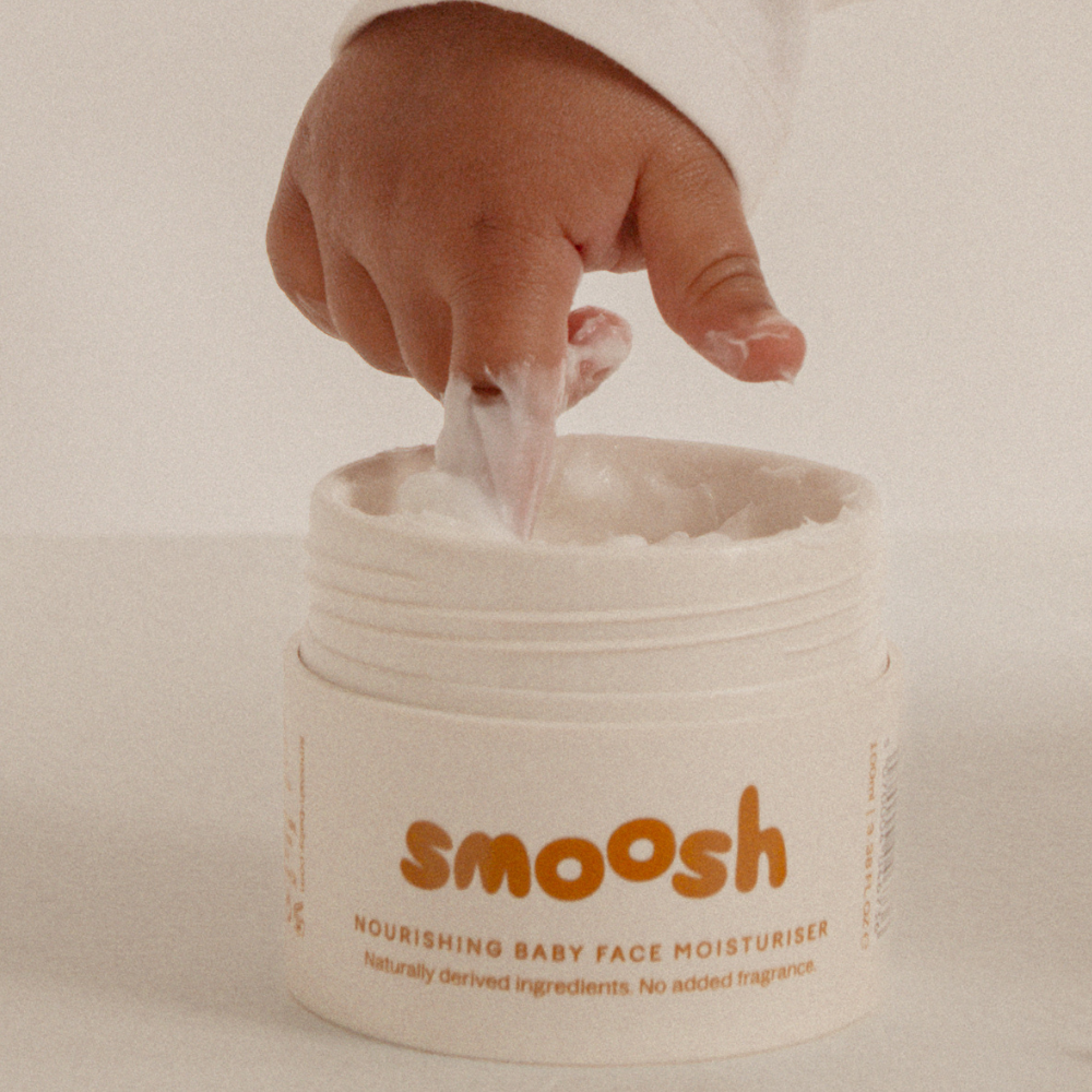 Scooping Smoosh baby face cream from the jar